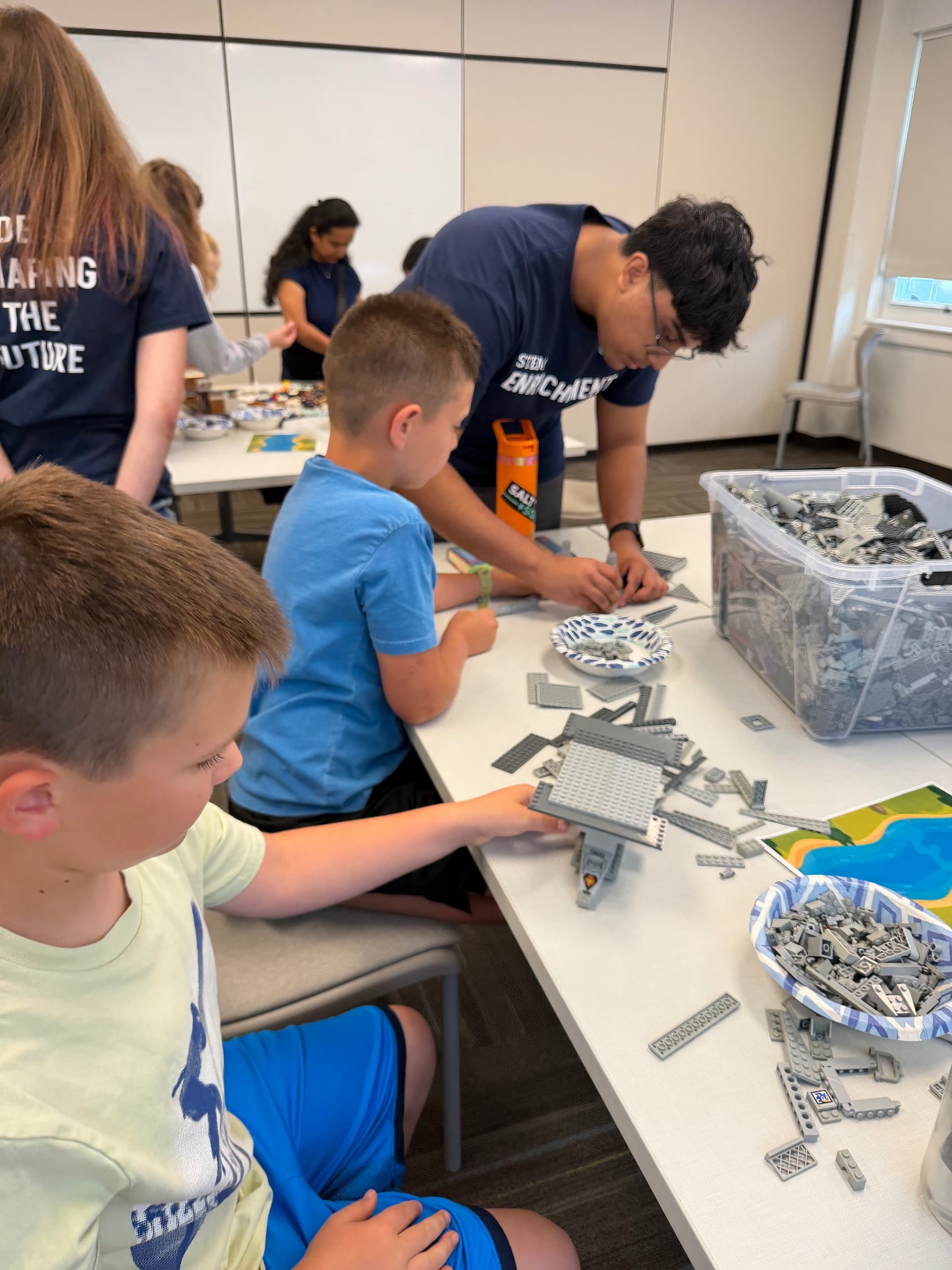 Mentor helping child — LEGO Bridge Building Workshop